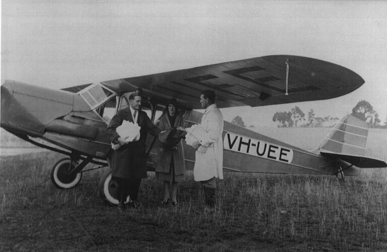 Lawrence Johnson (left), the pilot of Miss Flinders, handing over the mail bag and newspapers at Flinders Island.